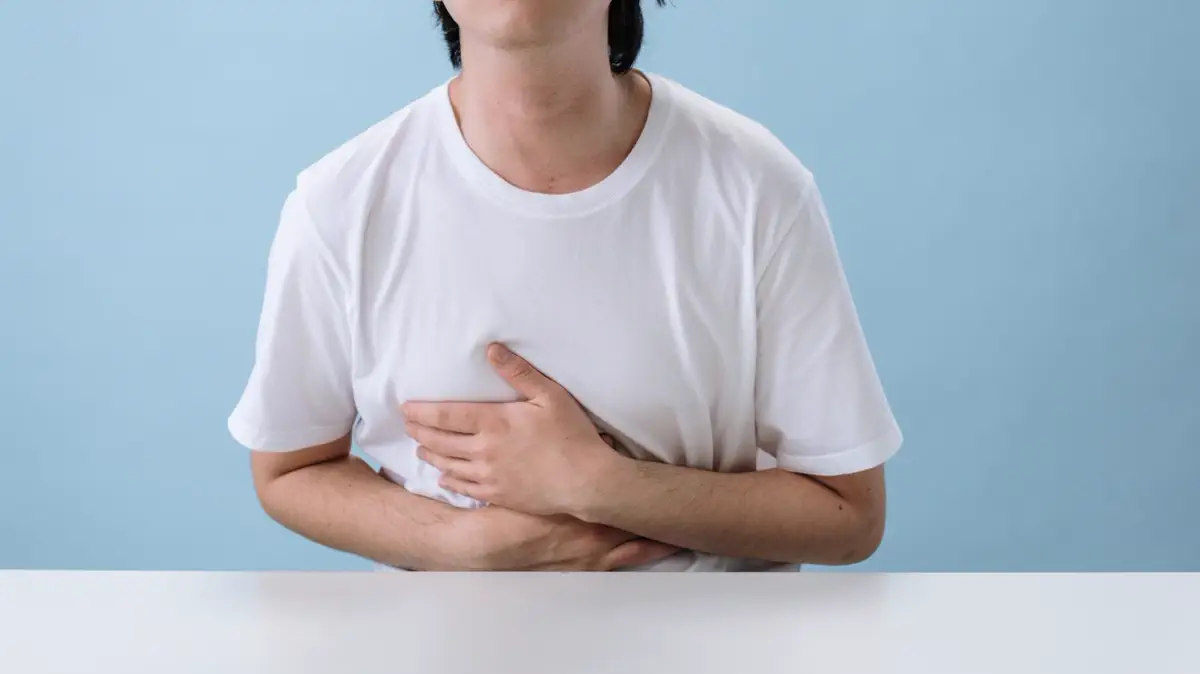 رجل ماسك على أعلى بطنه وصدره من حرقان المعدة